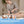 A woman uses a handheld professional body treatment device on a client's leg in a spa-like setting. The image includes two inset diagrams showing treatment areas labeled 'small area' and 'large area,' plus marketing text reading 'Advanced RET Energy System.